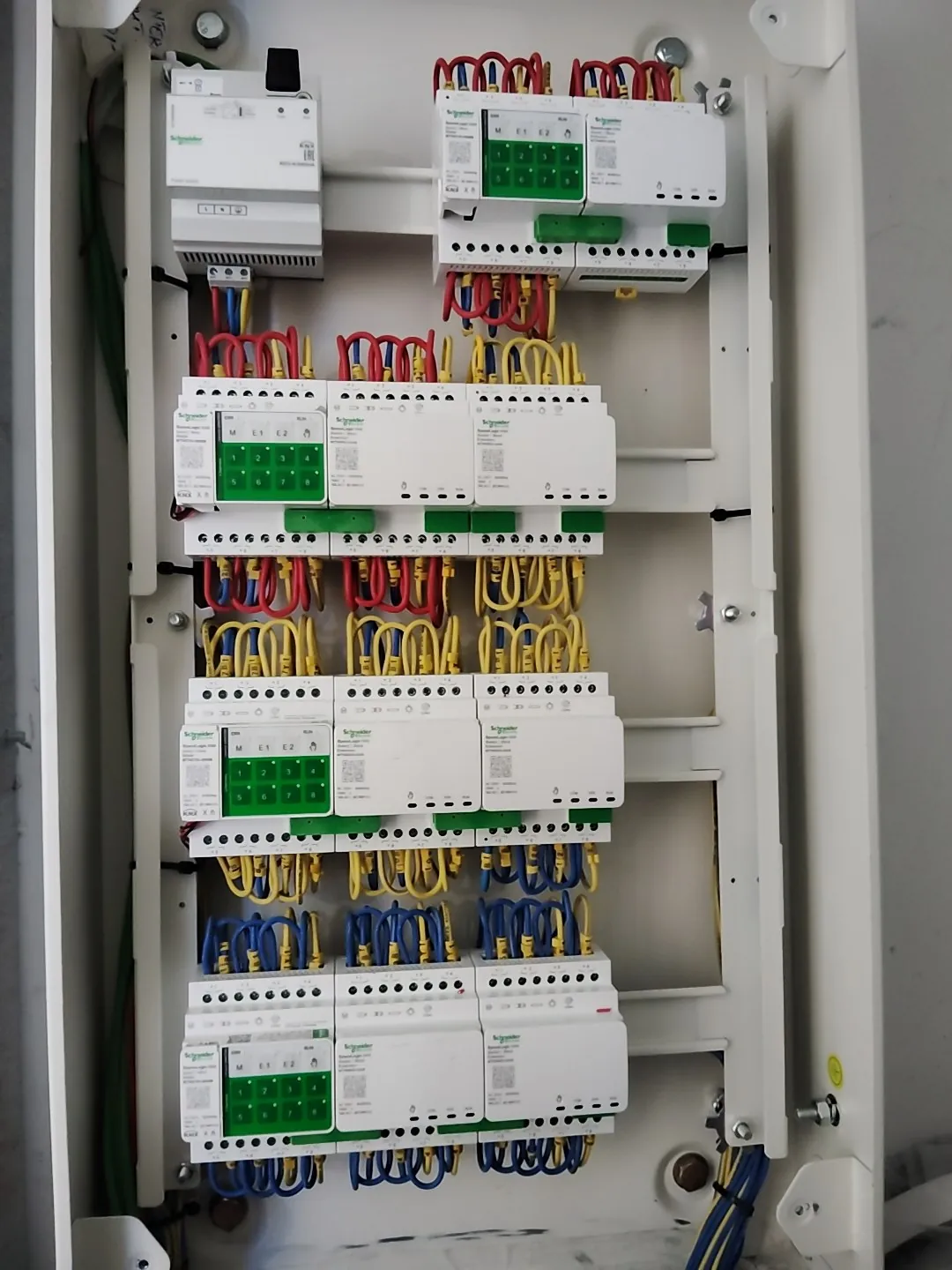 Lighting-control distribution panel with rows of control modules and colour-coded wiring