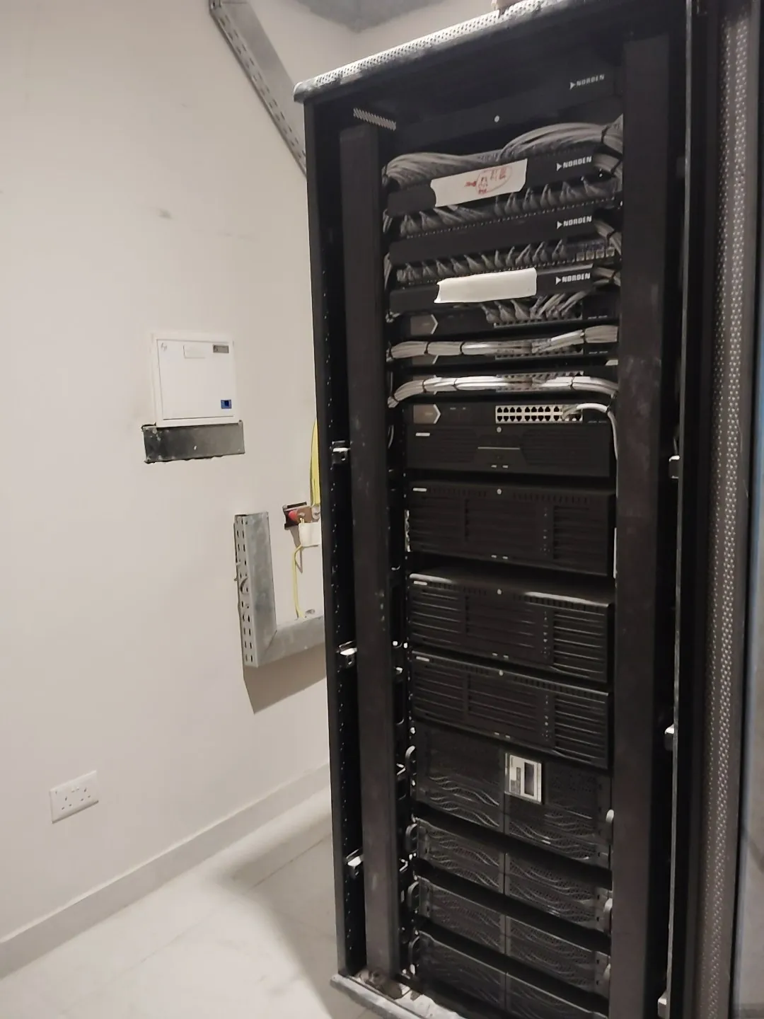 Floor network rack with patch panels and recorders installed in a riser room at R02 Tower