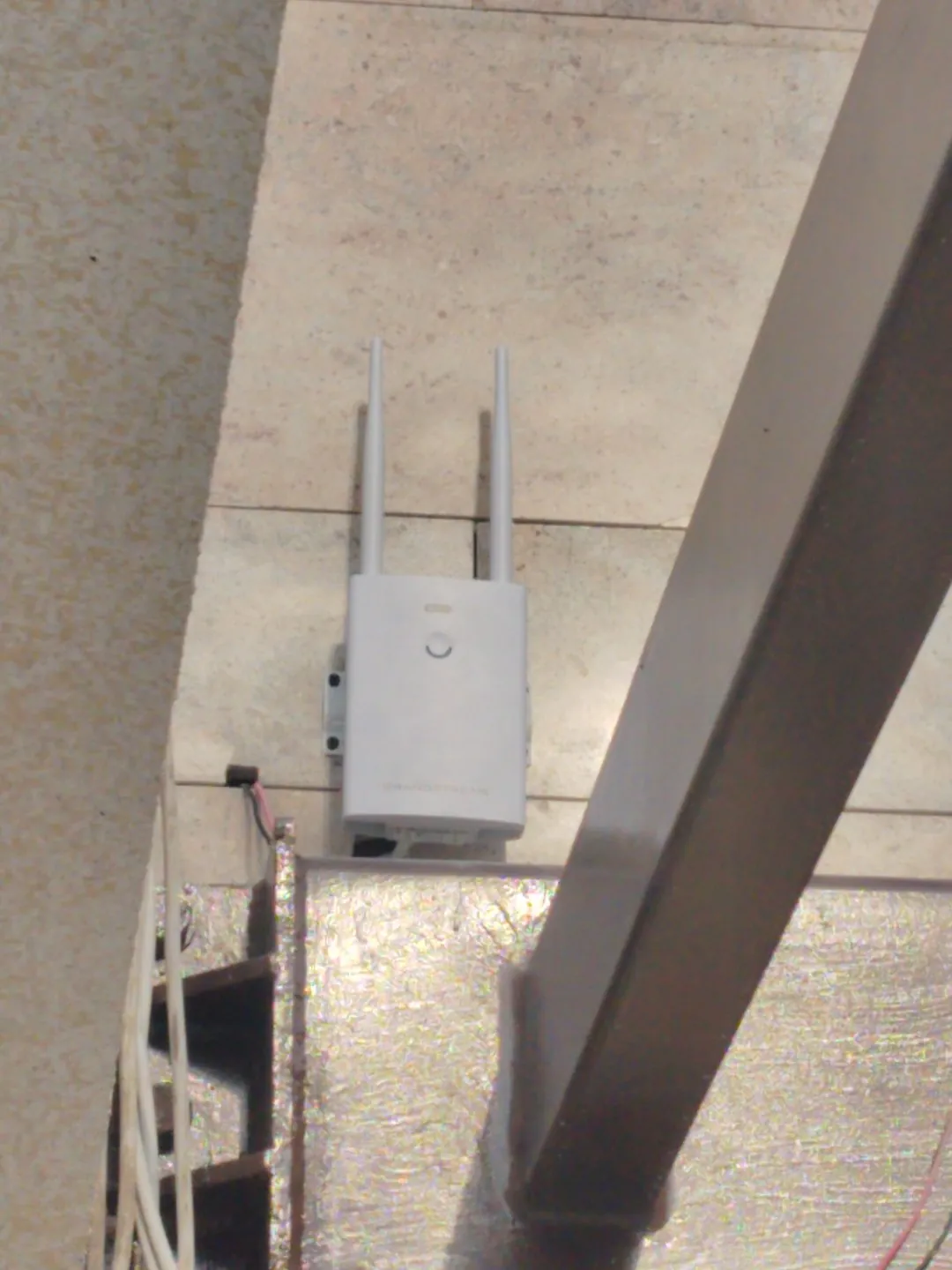 Wireless access point mounted on a riser wall next to the cable tray