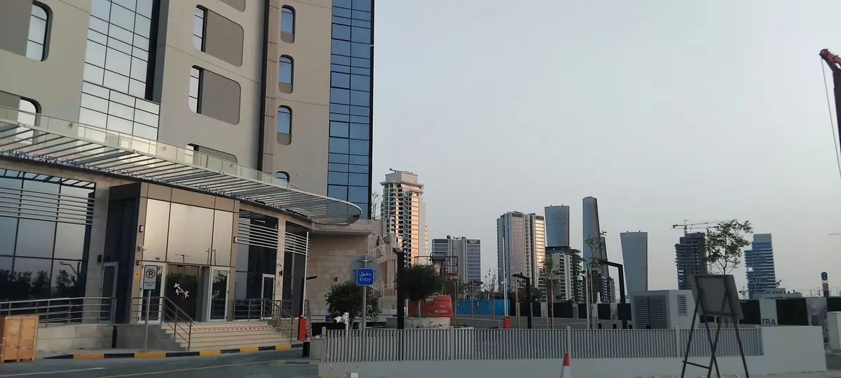 Voya Tower entrance and forecourt on the Lusail waterfront, with the Lusail skyline behind